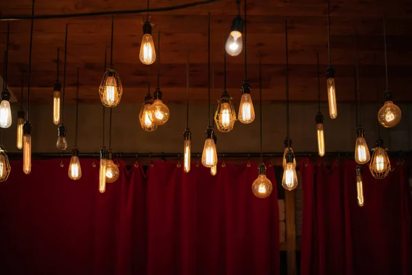 Kırmızı Perdelerin Üzerinde Asılı Edison Biçimli Filament Ampulleri