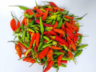 Beyaz arka planda bir yığın taze kırmızı ve yeşil biber.