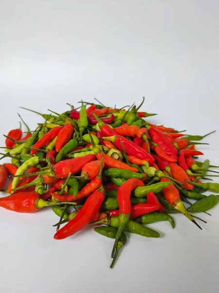Beyaz arka planda bir yığın taze kırmızı ve yeşil biber.