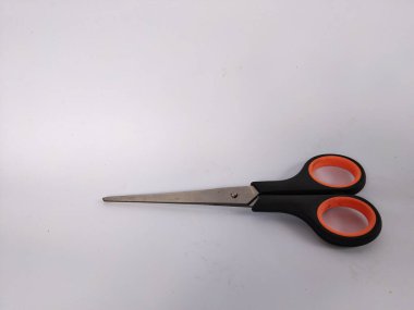 Siyah saplı, turuncu iç saplı, düz beyaz bir arka plana yerleştirilmiş bir makas çifti.