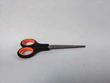 Siyah saplı, turuncu iç saplı, düz beyaz bir arka plana yerleştirilmiş bir makas çifti.