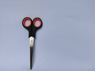 Siyah saplı, turuncu iç saplı, düz beyaz bir arka plana yerleştirilmiş bir makas çifti.