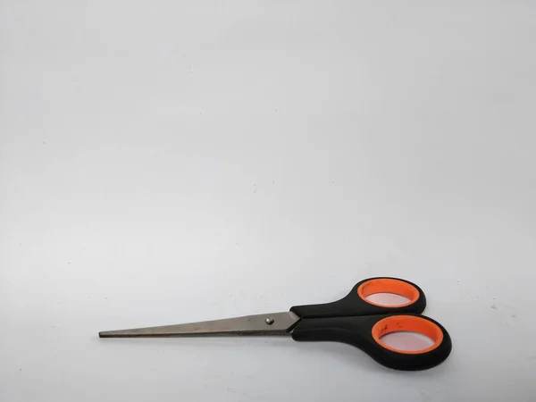 Siyah saplı, turuncu iç saplı, düz beyaz bir arka plana yerleştirilmiş bir makas çifti.