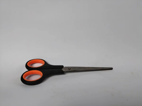 Siyah saplı, turuncu iç saplı, düz beyaz bir arka plana yerleştirilmiş bir makas çifti.