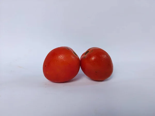 Beyaz arka plana yerleştirilmiş taze kırmızı domatesler doğal dokularını ve basit organik görünüşlerini sergiliyorlar.