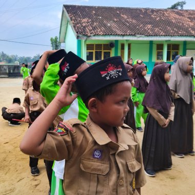 LAMPUNG, INDONESIA - 03 Ağustos 2025: Bir okul etkinliği sırasında bir grup yeşil üniformalı ve kahverengi tesettürlü öğrenci ayakta duruyor. Endonezya 3 Ağustos 2025.