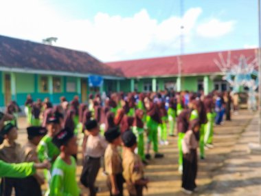 LAMPUNG, INDONESIA - 03 Ağustos 2025: Bir okul etkinliği sırasında bir grup yeşil üniformalı ve kahverengi tesettürlü öğrenci ayakta duruyor. Endonezya 3 Ağustos 2025.