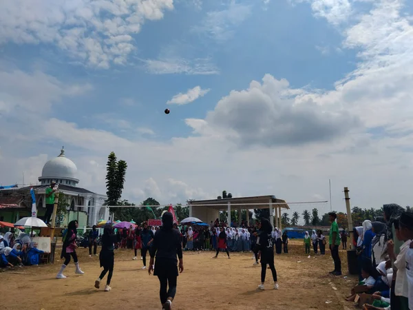 LAMPUNG, INDONESIA - 03 Ağustos 2025: Güneşli bir günde kızlar voleybol oynuyor, seyirciler ve hakem izliyor, Endonezya, 3 Ağustos 2025.
