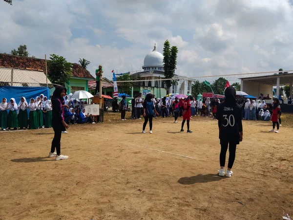 LAMPUNG, INDONESIA - 03 Ağustos 2025: Güneşli bir günde kızlar voleybol oynuyor, seyirciler ve hakem izliyor, Endonezya, 3 Ağustos 2025.