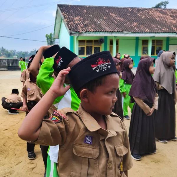LAMPUNG, INDONESIA - 03 Ağustos 2025: Bir okul etkinliği sırasında bir grup yeşil üniformalı ve kahverengi tesettürlü öğrenci ayakta duruyor. Endonezya 3 Ağustos 2025.