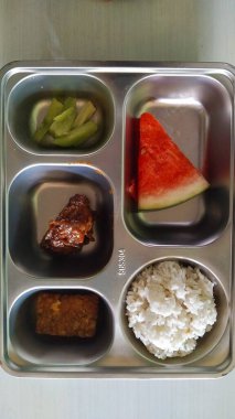 Dengeli Endonezya yemeği içeren paslanmaz çelik yemek tepsisi.