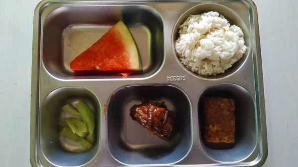 Dengeli Endonezya yemeği içeren paslanmaz çelik yemek tepsisi.