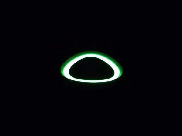 Tamamen karanlık bir arkaplanda parıldayan bir ışık halkası