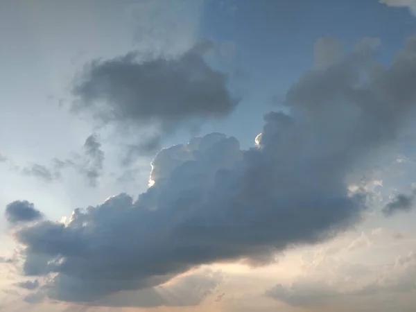 Yumuşak beyaz bulutlarla dolu, berrak, mavi bir gökyüzü.