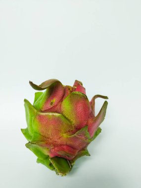 Canlı pembe ve yeşil derili taze bir ejderha meyvesi (pitaya) temiz beyaz arka planda sergilenir