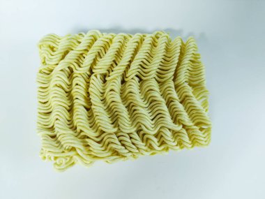 Temiz beyaz bir arkaplana yerleştirilmiş pişmemiş hazır eriştenin yakın plan çekimi.