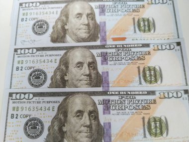 Temiz beyaz bir arkaplan üzerine yerleştirilmiş 100 dolarlık banknotlar.