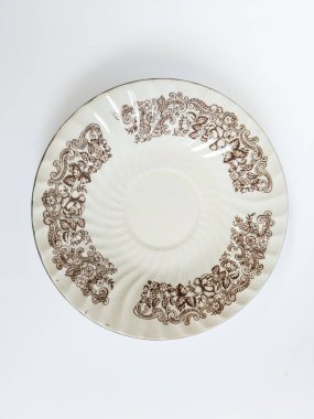 Dekoratif seramik bir plaka. Klasik çiçek desenli. Kahverengi, mavi ve kırmızı.