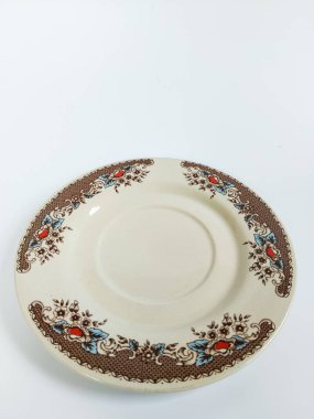 Dekoratif seramik bir plaka. Klasik çiçek desenli. Kahverengi, mavi ve kırmızı.