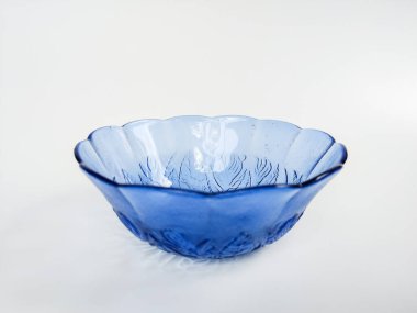 İç yüzeyine oyulmuş zarif çiçek desenli şeffaf mavi bir cam kase.