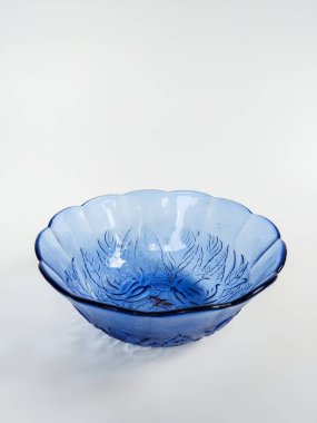 İç yüzeyine oyulmuş zarif çiçek desenli şeffaf mavi bir cam kase.