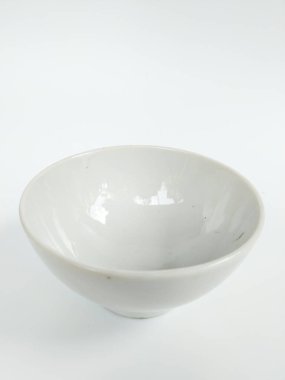 Pürüzsüz, parlak kaplamalı, beyaz arka planda beyaz bir seramik kase.