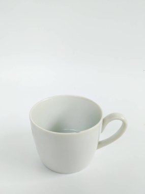 Boş beyaz bir seramik kupanın minimalist bir stüdyo fotoğrafı temiz beyaz bir arka plana yerleştirilmiş..