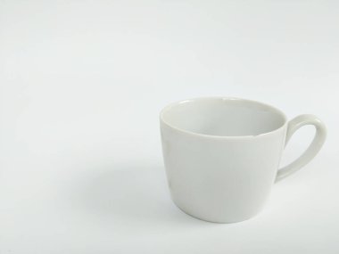 Boş beyaz bir seramik kupanın minimalist bir stüdyo fotoğrafı temiz beyaz bir arka plana yerleştirilmiş..