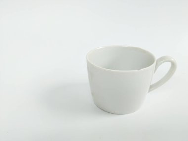 Boş beyaz bir seramik kupanın minimalist bir stüdyo fotoğrafı temiz beyaz bir arka plana yerleştirilmiş..