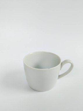Boş beyaz bir seramik kupanın minimalist bir stüdyo fotoğrafı temiz beyaz bir arka plana yerleştirilmiş..