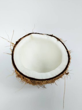 Temiz beyaz bir arkaplana yerleştirilmiş yarım hindistan cevizinin yakın plan çekimleri.