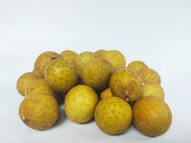 Temiz beyaz bir arkaplanda düzgün sıralanmış olgun bir longan meyvesi kümesi.