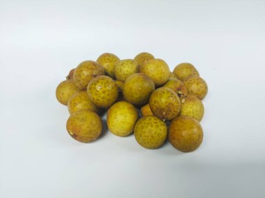 Temiz beyaz bir arkaplanda düzgün sıralanmış olgun bir longan meyvesi kümesi.