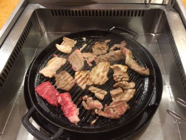 Kore barbekü restoranının elektrikli ocağında çeşit çeşit et ızgara.