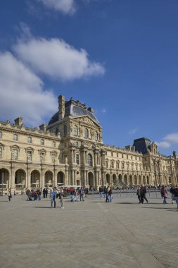 Paris 'te güneşli bir sonbahar gününün tadını çıkaran turistlerle Louvre Müzesi cephesinin ayrıntılı görüntüsü. Paris, Fransa - 14 Ekim 2025