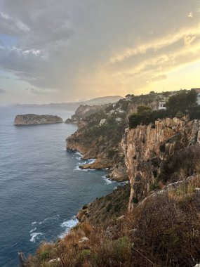Gün batımında dramatik gökyüzü ile Rocky sahili..