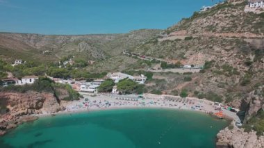İspanya 'nın Javea kentindeki Cala Granadella Körfezi' nin hava aracı görüntüleri turkuaz suyu, plaj şemsiyeleri ve kayalık tepelerle çevrili güzel Akdeniz kıyılarını gösteriyor..