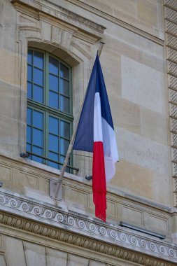 Fransa 'nın başkenti Paris' teki tarihi bir binanın cephesinden sarkan Fransız üç renkli bayrağının yakın çekimi.