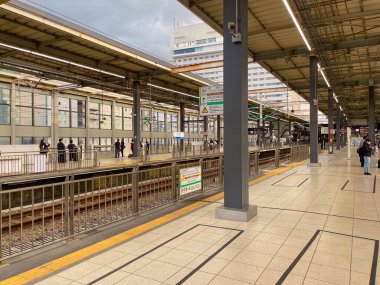 Platformları ve bekleyen insanları olan modern Japon tren istasyonu. Hiroşima, Japonya - 1 Kasım 2025.