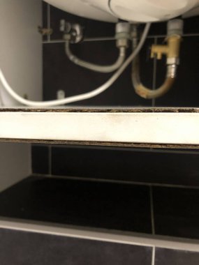 İç su ısıtıcısının görünür boruları, tesisatı, elektrik kablosu ve kabin raf aşınması olan alt kısmının detaylı görünümü bakım, onarım ve ev tesisat sistemleri için uygundur..