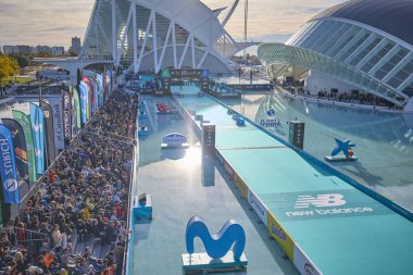 İkonik Sanat ve Bilim Şehri yakınlarında Valencia Maratonu 'nu izleyen kalabalık, damgalı sancaklar, mavi koşu platformu ve bitiş alanı sporcular için hazırlandı. Valencia, İspanya - 7 Aralık 2025.