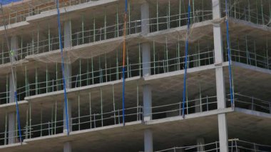İnşaat halindeki beton bina, ağlar, direkler ve raylarla yakından görülüyor. Yapısal zemin, güvenlik ağı ve çok katlı bir binada görülen destek çubukları. Valencia, İspanya - 30 Temmuz 2025.
