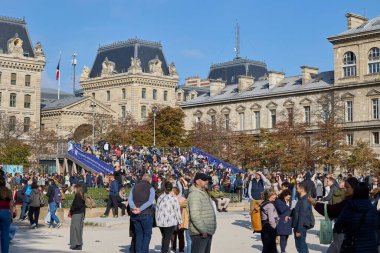 Paris 'teki Notre Dame Katedrali yakınlarında toplanan kalabalık, tarihi binalarla çevrili güneşli bir günün tadını çıkarıyordu. Paris, Fransa - 11 Ekim 2025.
