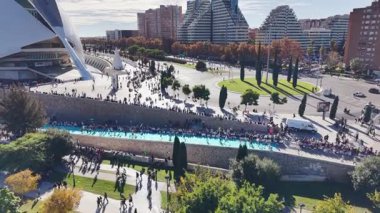 İnsansız hava aracı görüntüleri, modern konut binalarının yanındaki kavşağın yanından geçen maraton koşucularını gösteriyor. 2025 Valencia Maratonu Alfonso Zürih. Valencia, İspanya - 7 Aralık 2025.