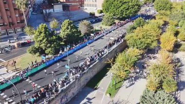 İHA görüntüsü, yerleşim yerleri ve izleyicilerle çevrili dar şehir sokaklarında ilerleyen maraton koşucularını yakalıyor. 2025 Valencia Maratonu Alfonso Zürih. Valencia, İspanya - 7 Aralık 2025.