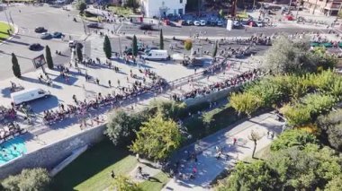 İnsansız hava aracı görüntüleri, modern konut binalarının yanındaki kavşağın yanından geçen maraton koşucularını gösteriyor. 2025 Valencia Maratonu Alfonso Zürih. Valencia, İspanya - 7 Aralık 2025.