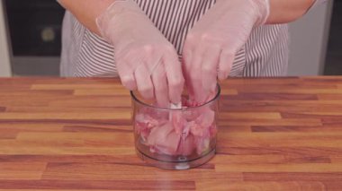 Çiğ tavuk eti kıyma için gıda işlemcisine karıştırılıyor.