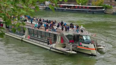 Paris 'teki Seine Nehri boyunca seyahat eden yolcularla dolu bir turistik nehir. Paris, Fransa - 10 Ekim 2025.