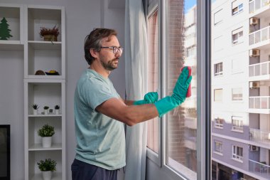 Sünger ve spreyle evde cam temizliği.