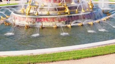 Versailles Sarayı 'ndaki süslü bir çeşmede yaldızlı heykellerin ve akan suyun ayrıntılı manzarası. Versailles, Fransa - 12 Ekim 2025.